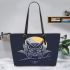 An owl perched on a branch during a moonlit night leather tote bag