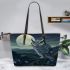 An owl perched on a branch in front of a moonlit landscape leather tote bag