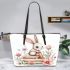 Baby rabbit sitting on top of books surrounded by flowers leather tote bag