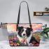 Black and white border collie sits in the foreground amidst blooming flowers leather tote bag