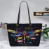 Colorful dragonfly among flowers leather tote bag