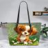 Cute brown and white puppy sits on the grass leather tote bag