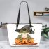 Cute cartoon frog wearing a witch's hat sitting on a pumpkin leaather tote bag