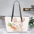 Cute cartoon rabbit holding a carrot leather tote bag
