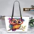 Cute colorful owl with big eyes sitting on a tree branch leather tote bag