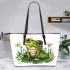 Cute frog sitting on the grass with flowers leaather tote bag