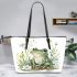 Cute frog sitting on the ground with flowers leaather tote bag