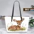 Cute little fawn sitting in the grass leather totee bag