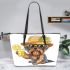 Cute yorkshire terrier in a summer hat and sunglasses holding leather tote bag