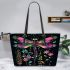 Dragonfly is flying surrounded by flowers leather tote bag