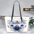 Dragonfly with blue flowers leather tote bag