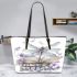 Elegant dragonfly perched on top of open books leather tote bag
