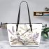 Elegant dragonfly perched on top of open books leather tote bag