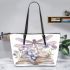 Elegant dragonfly perched on top of open books leather tote bag