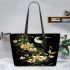 Flowers and dragonflies around the moon leather tote bag