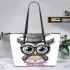 Grey owl with big eyes wearing glasses and graduation hat holding leather tote bag