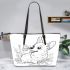 Happy corgi with a butterfly on its nose in a garden leather tote bag