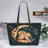 Two cute owls in love sitting on the crescent moon leather tote bag
