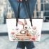 Baby rabbit sitting on top of books surrounded by flowers leather tote bag