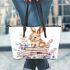 Baby rabbit sitting on top of books surrounded by flowers leather tote bag