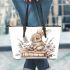 Baby rabbit sitting on top of books surrounded by flowers leather tote bag