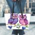 Cute and adorable two purple and pink owls sitting on the branch leather tote bag