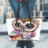 Cute baby owl with big eyes wearing leather tote bag