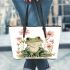 Cute cartoon frog sitting on the ground with pink flowers leaather tote bag