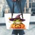 Cute cartoon frog wearing a witch hat sitting on a pumpkin leaather tote bag