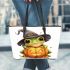 Cute cartoon frog wearing a witch hat sitting on a pumpkin leaather tote bag