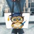 Cute cartoon owl with glasses and graduation hat holding book leather tote bag
