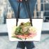 Cute frog sitting on the flower leaather tote bag