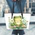 Cute frog sitting on the grass with flowers leaather tote bag