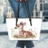 Cute little fawn sitting in the grass leather totee bag