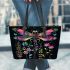 Dragonfly is flying surrounded by flowers leather tote bag