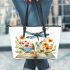 Dragonfly sitting on an open book surrounded by flowers leather tote bag