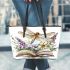 Dragonfly sitting on an open book surrounded flowers leather tote bag