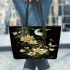 Flowers and dragonflies around the moon leather tote bag