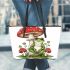 Red and white mushroom with green frog sitting on it leaather tote bag