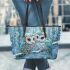 Two cute owls with feathers in shades of blue leather tote bag