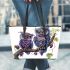 Two cute purple and blue owls sitting on the branch leather tote bag