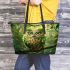 An owl with green feathers perched on the branch leather tote bag