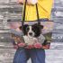 Black and white border collie sits in the foreground amidst blooming flowers leather tote bag