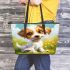 Cute cartoon puppy sitting on the grass leather tote bag