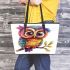 Cute colorful owl with big eyes sitting on a tree branch leather tote bag