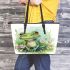 Cute frog sitting on the grass with flowers leaather tote bag