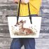 Cute little fawn sitting in the grass leather totee bag