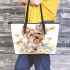Cute little yorkshire terrier with long hair and bows in her ears leather tote bag