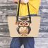 Cute owl wearing glasses and a graduation hat in a simple leather tote bag