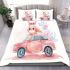 Cute pink owl sitting on top of a pastel car bedding set